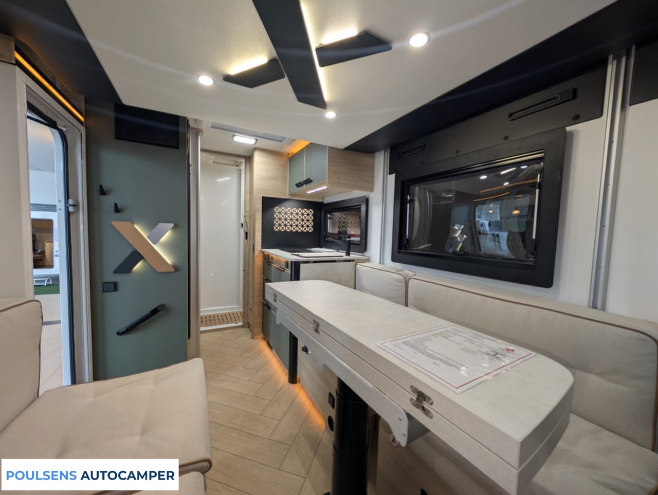 Salon intérieur du camping-car compact Challenger X150 2025 avec banquettes confortables et table centrale