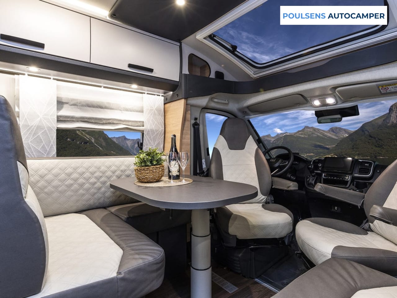 Salon intérieur du camping-car semi-intégré Knaus LIVE TI 700 MEG Platinum Selection 2026 avec banquettes et table télescopique