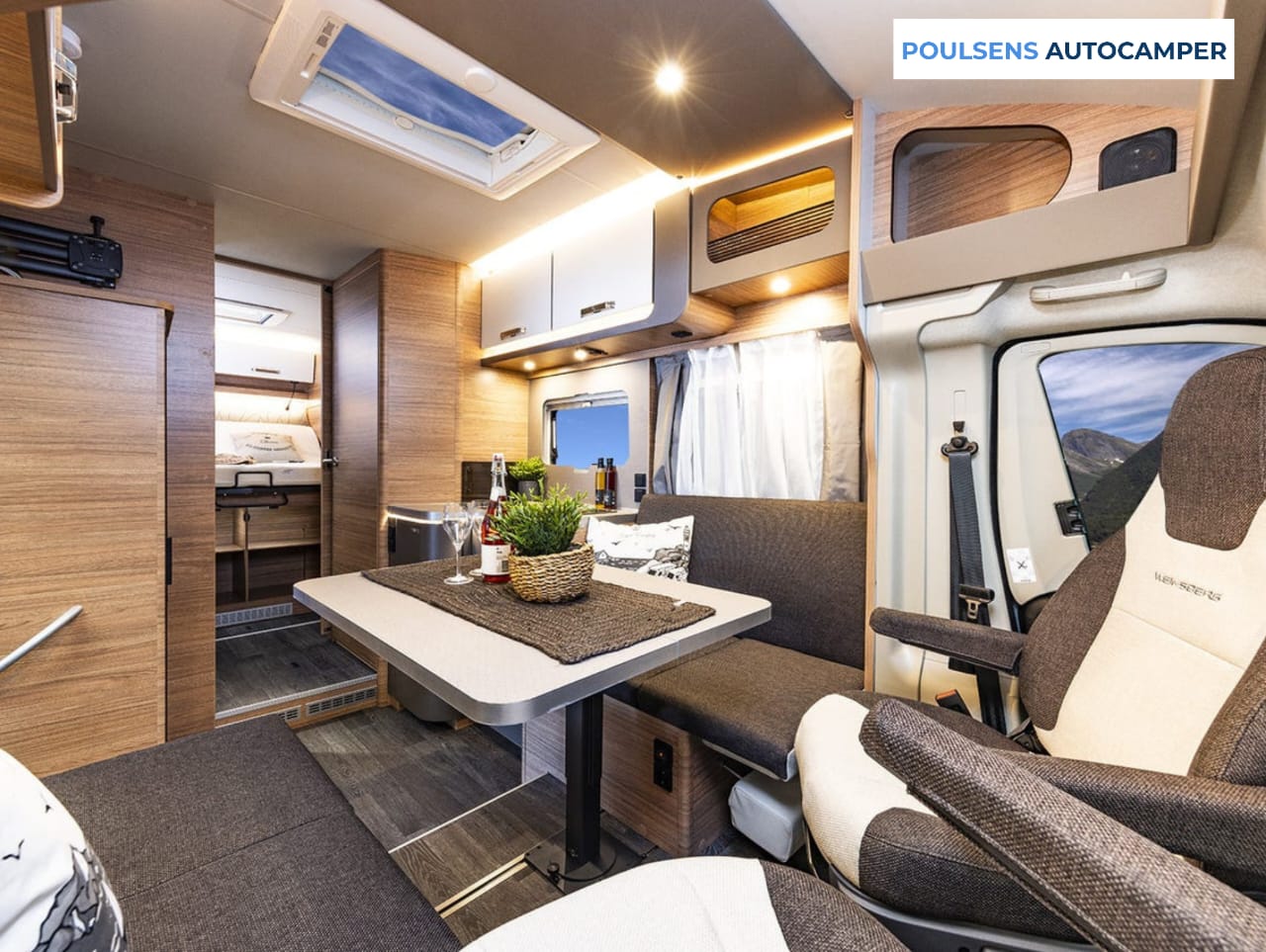Salon intérieur du camping-car semi-intégré Weinsberg CARASUITE 700 DX 2026 avec banquettes, éclairage LED et table centrale